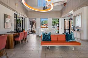 A modern interior with a long orange sofa and a wooden table.