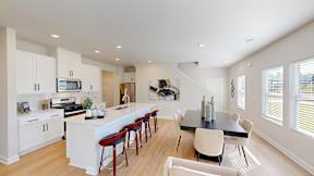 A modern kitchen with white cabinets and a black island.