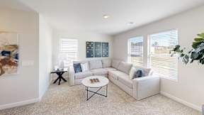 A living room with a white couch, a coffee table, and a painting on the wall.
