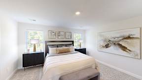 A bedroom with a large bed and a painting on the wall.