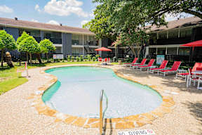 A pool surrounded by chairs and a "No Diving" sign.