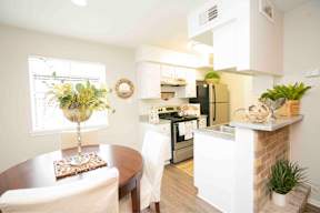 A kitchen with a white countertop and a white chair.
