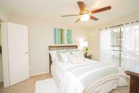 A bedroom with a large bed and a ceiling fan.