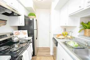A kitchen with a black stove top oven and a black refrigerator.