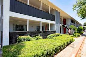 A modern building with a white and black facade and a red door.