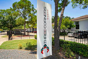 A sign for "Three Corners North" is displayed on a tree.