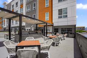 A patio with chairs and tables is in front of a building.
