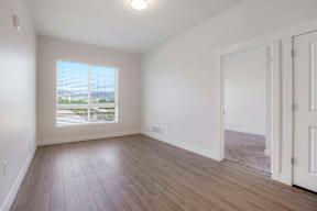 A room with a large window and a wooden floor.