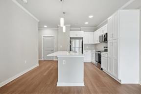 A modern kitchen with white cabinets and a center island.