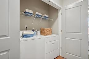 A small white laundry room with a washer and dryer.