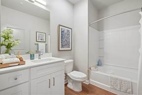 A white bathroom with a toilet, sink, and bathtub.