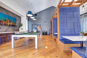 A room with a pool table and a bar area.