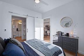 A bedroom with a bed, dresser, and mirror.