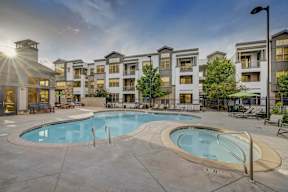 A large swimming pool in front of apartment buildings.