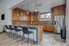 A kitchen with a bar area and chairs.