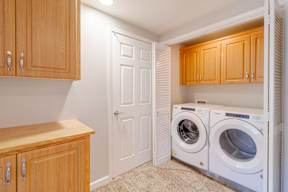 A laundry room with a white door and two washing machines.