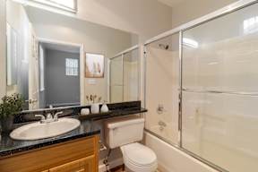 A bathroom with a toilet, sink, and shower.