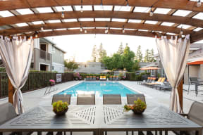 Dog-Friendly Apartments in Pleasanton, CA - Civic Square - Pool with a Wooden Cabana, Seating Area, and Lounge Chairs