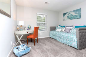 a bedroom with a bed and a desk with a chair