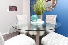a small dining room with a glass table and chairs