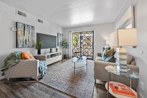 A living room with a couch, chair, and television.