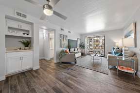 Bright living room with ceiling fan at Station 21 apartments in Mesa, AZ.