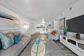 Modern living room with grey sofa and glass coffee table at Station 21 apartments for rent in Mesa, AZ.