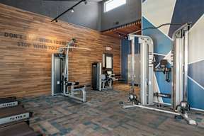 A gym with a wooden wall and a sign that says "Don't stop when you're tired" at Station 21 apartments for rent in Mesa.