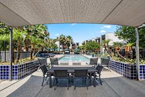 A patio with a table and chairs under a white canopy.