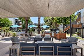 A patio with a table and chairs under a white canopy.
