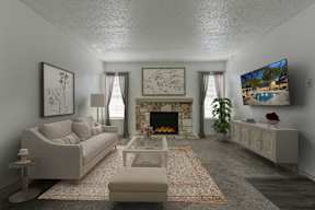 A living room with a fireplace and a television on the wall.
