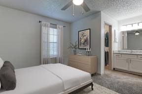 A bedroom with a bed, dresser, and mirror.