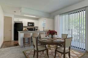 A dining room with a table set for four.