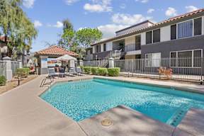 A swimming pool in a residential area with a building in the background.