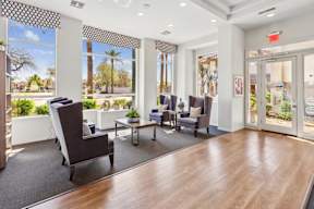 A waiting room with a view of the outdoors through the windows.