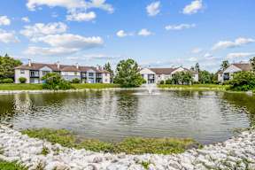 A serene lake surrounded by houses and a clear blue sky.