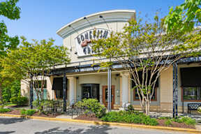 A restaurant named Bonefish Grill is surrounded by greenery and has a clear blue sky above.