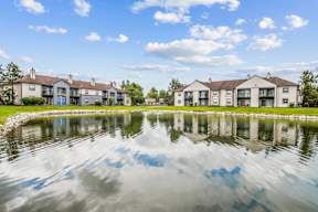 A row of houses are reflected in the water.