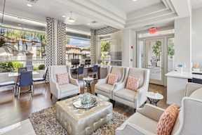A living room with a white sofa and a glass coffee table.