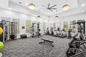 A spacious gym with a variety of equipment including treadmills, weights, and exercise machines at Brandywine Green.