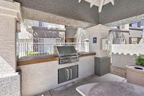 A patio with a grill and a table.