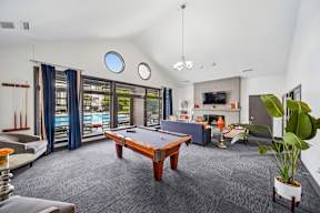 A room with a pool table and a couch.