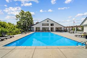 A large swimming pool in front of a house.