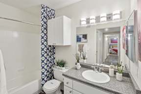 A bathroom with a white toilet, sink, and a mirror.