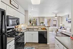 A kitchen with white cabinets and a black stove top oven.