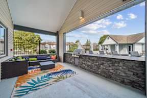 A patio with a stone wall and a couch.