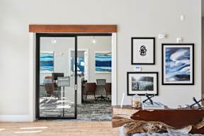 A modern living room with a glass door entrance and a wooden coffee table.