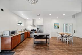 A kitchen with wooden floors and a dining table.