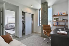 A modern office with a desk, chair, and bookshelf.