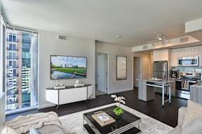 A modern living room with a large flat screen TV mounted on the wall.